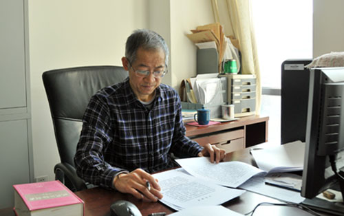 图为张仲华同志在认真校核文件